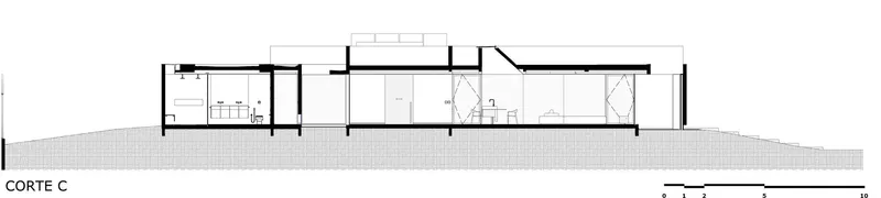 Section drawing showing interior rooms and circulation along the sloping site grade
