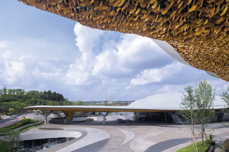 Exterior view of the golden scalloped canopy roof sheltering the white curved entrance pavilion below