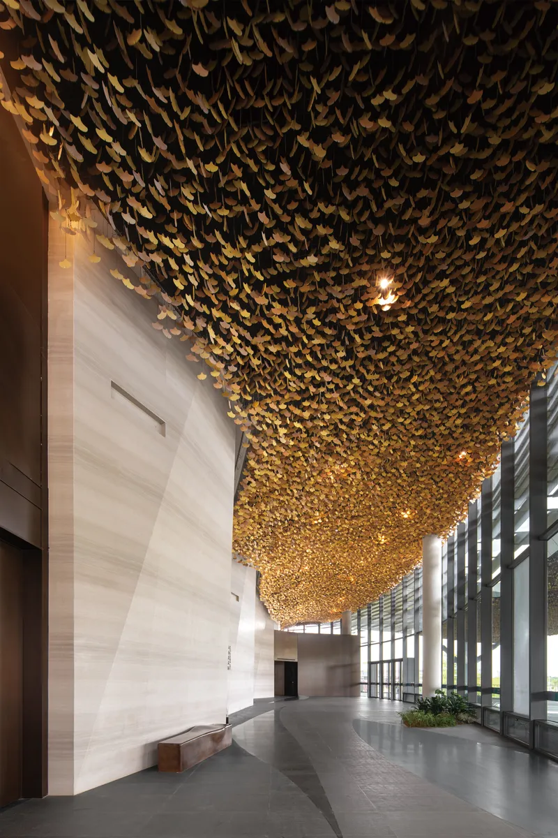Entrance lobby with textured golden ceiling installation cascading above the polished stone floor
