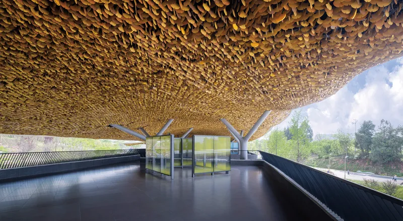 Interior view of the golden scalloped ceiling canopy supported by branching columns overlooking green fields