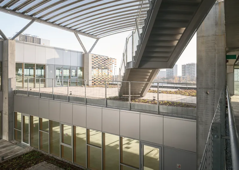 Exterior terrace with concrete staircase, metal cladding and patterned canopy structure above