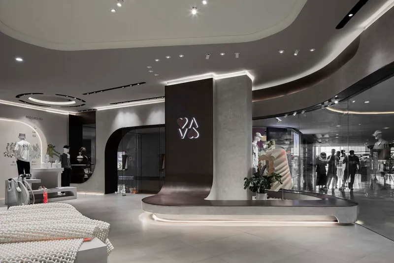 Central circulation space showing the curved reception desk with backlit signage and shoppers in the background