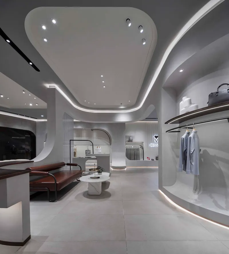 Seating area with curved ceiling soffit and illuminated display niches along perimeter wall