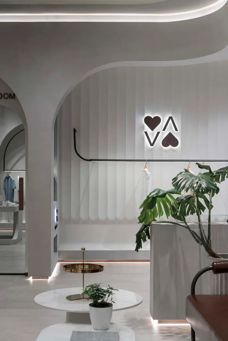 Vertical striped wall panels with backlit logo and arched openings framing merchandise displays