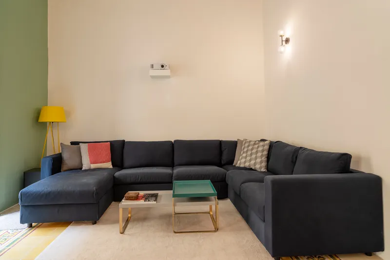 Living room with dark sectional sofa against olive green and cream walls
