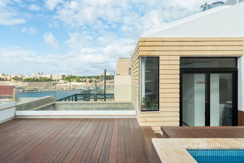 Rooftop terrace with timber decking, horizontal wood cladding and a small pool under cloudy skies