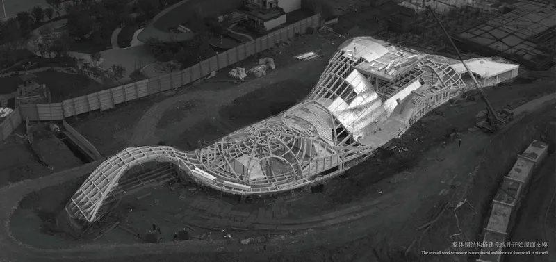 Aerial view of the undulating structural framework with exposed ribs during construction