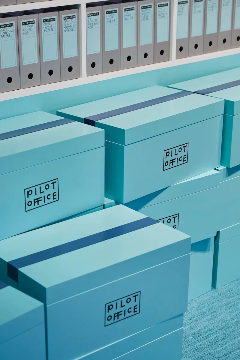 Storage boxes and binders arranged on stepped shelving units in a coordinated color scheme