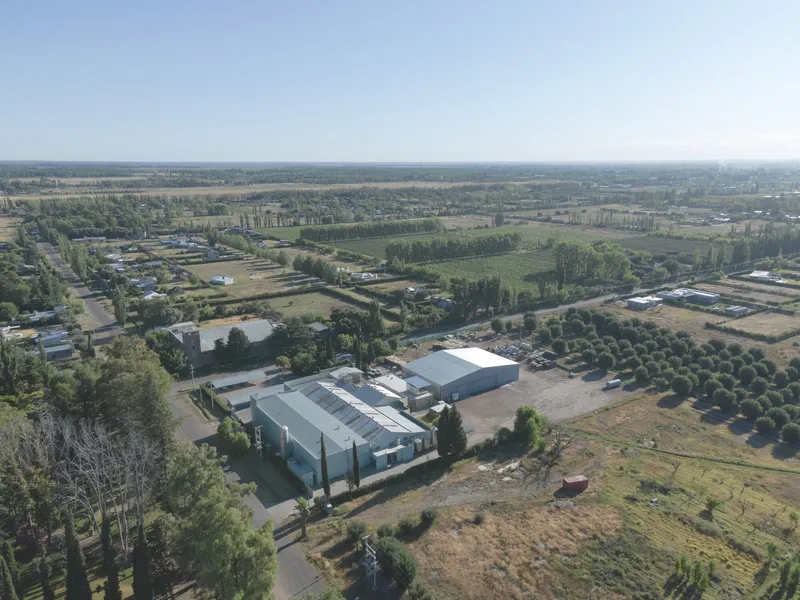 Aerial view of the metal-roofed warehouse complex surrounded by agricultural fields and tree rows