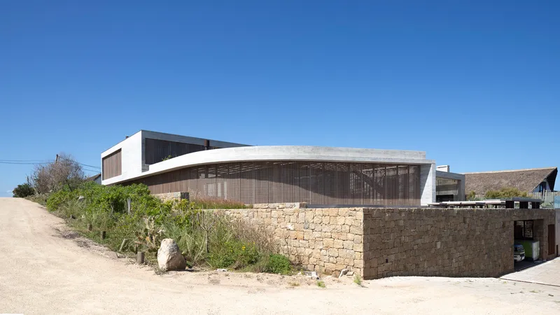 Street view of the stone base wall topped by timber lattice screen and concrete roof canopy