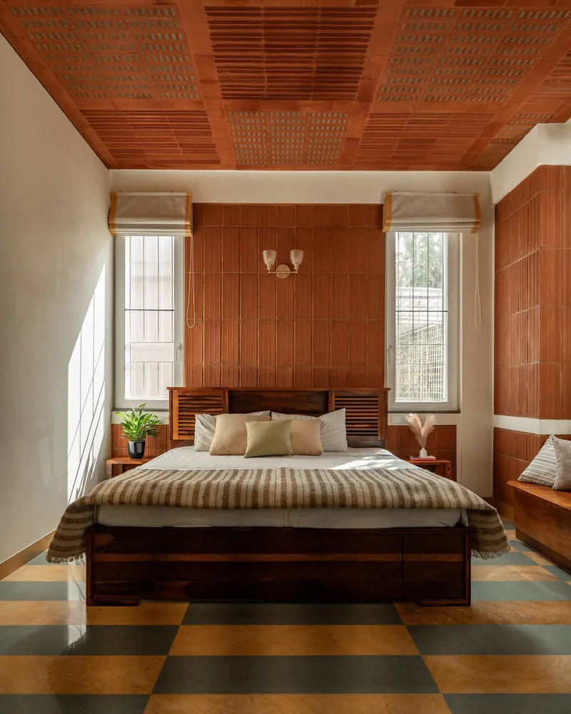 Bedroom with coffered timber ceiling and vertical-slatted accent wall flanked by tall windows