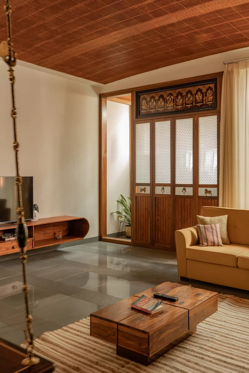Interior with decorative timber partition, polished stone floor and warm afternoon light from windows