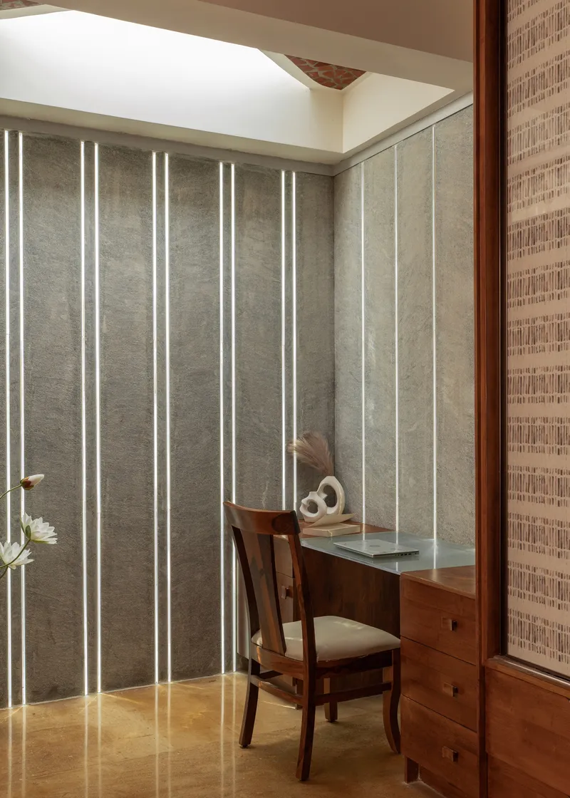 Corner study nook with vertical LED strips integrated into translucent wall panels beside timber desk