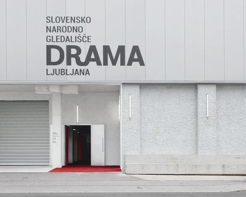 Entrance facade with white vertical paneling, red carpet entry and horizontal stone base with recessed panels