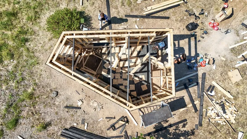 Aerial view of the exposed timber frame structure during construction with workers on site
