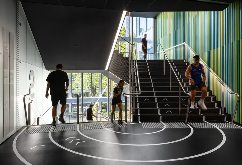 Entry foyer with central staircase and concentric circle floor pattern as visitors ascend and descend