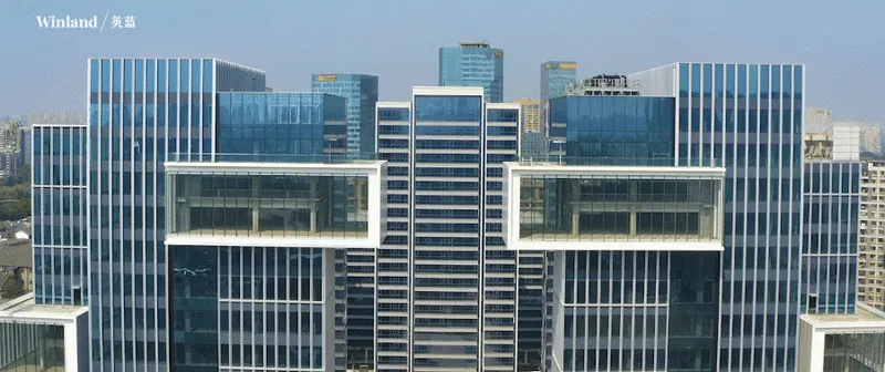 Close-up of stacked horizontal office blocks spanning between vertical glass-clad towers