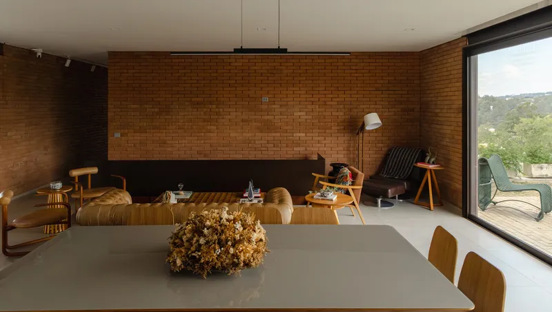 Living room with exposed brick wall, recessed fireplace and sliding glass doors to the terrace