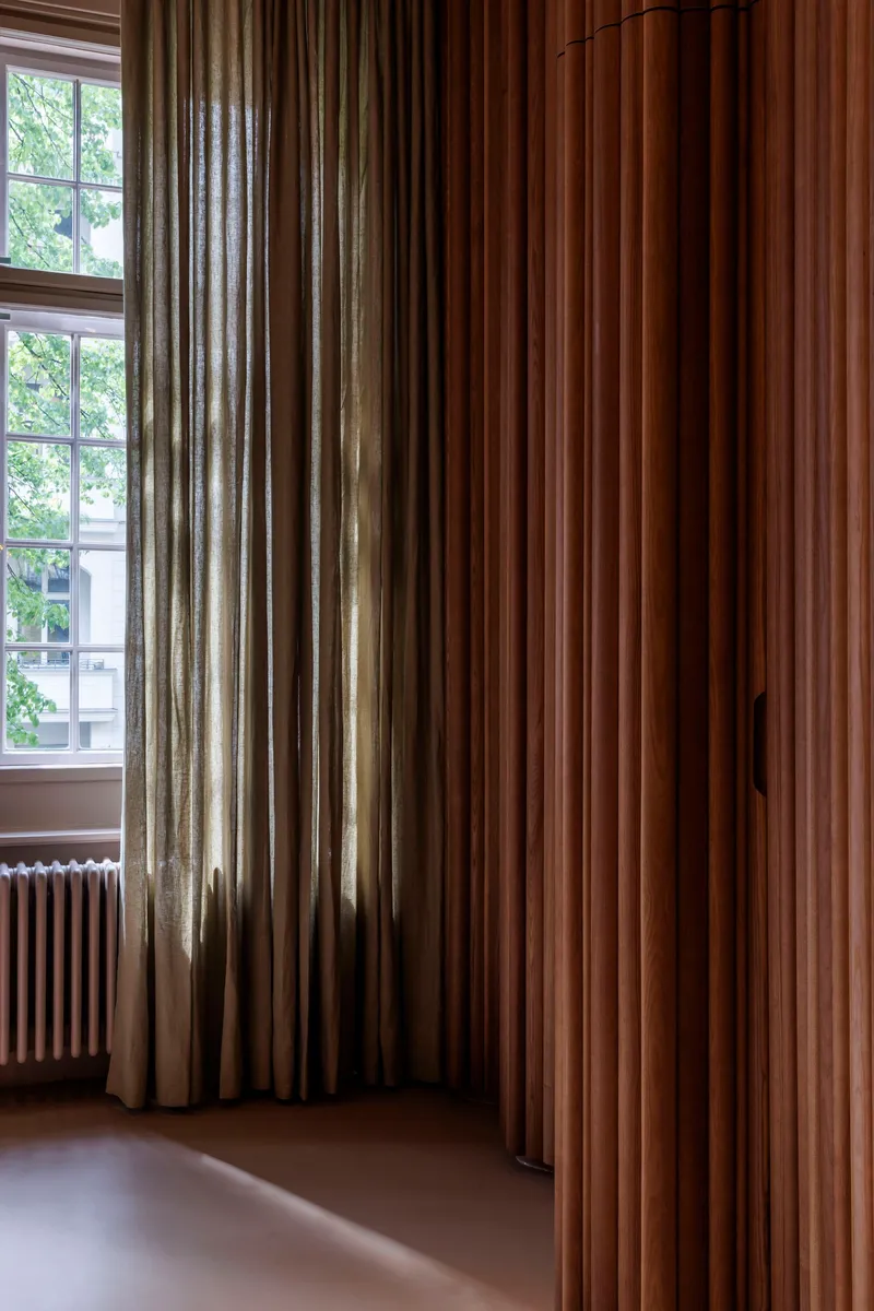 Floor-to-ceiling curtains in beige and brown tones framing a window with natural daylight