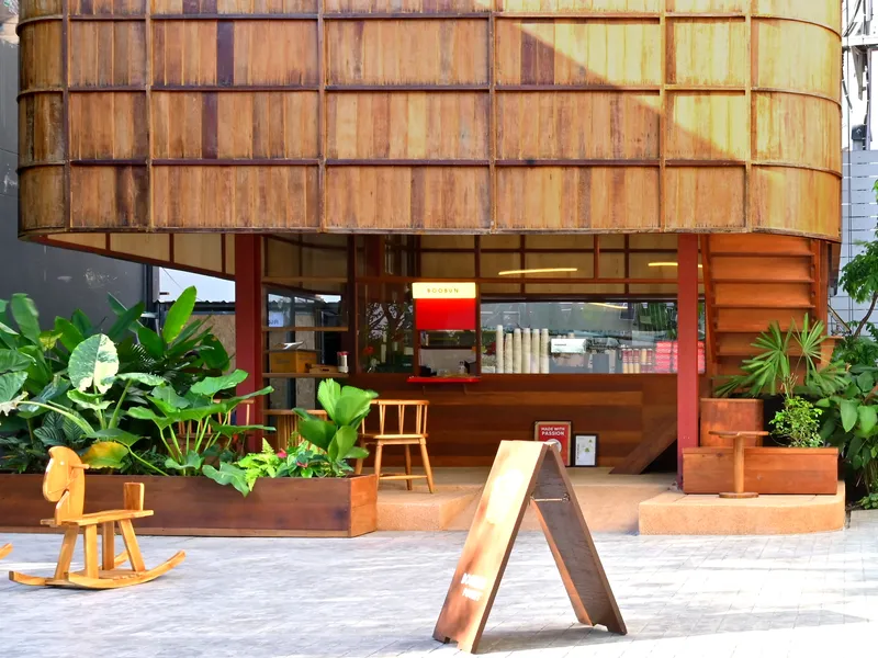 Street-level entry with timber service counter and planted courtyard with tropical foliage