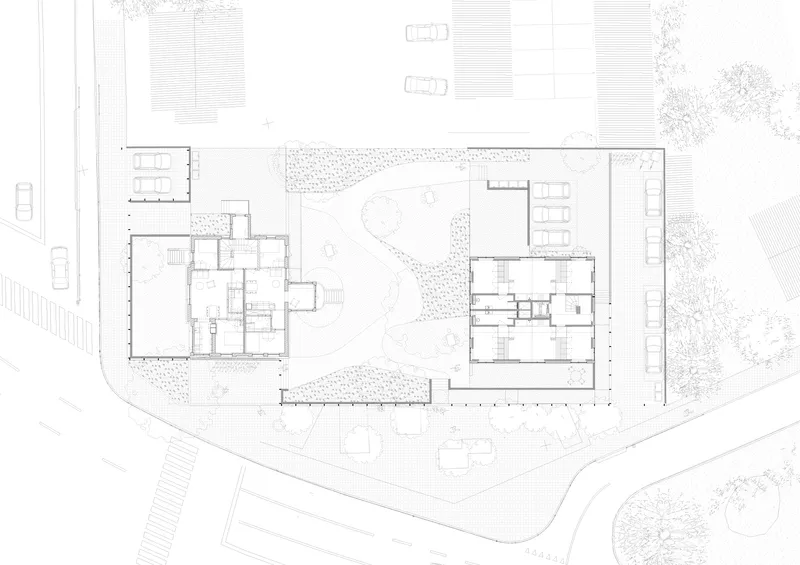 Site plan drawing showing two rectangular buildings flanking a courtyard with landscaping and parking areas