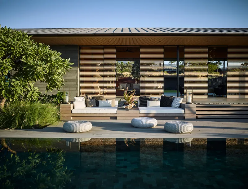 Horizontal timber louvers screening the glazed facade above a reflecting pool and terrace seating