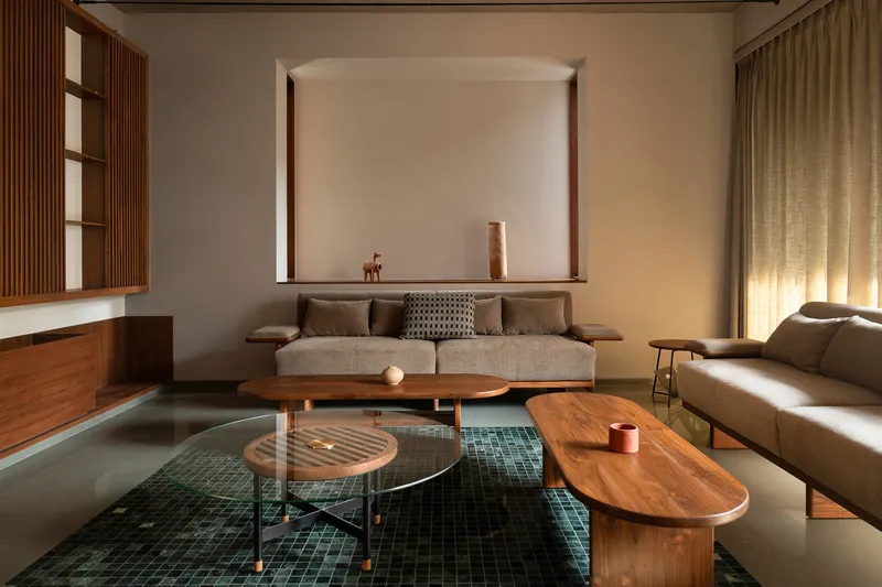 Living room with timber furniture arranged around a sunken green mosaic tile panel in the floor