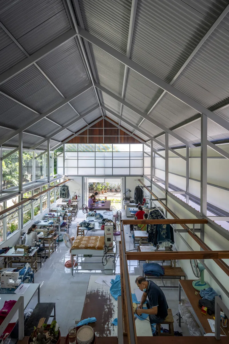 Interior view of the double-height workspace with exposed gabled roof trusses and translucent panels