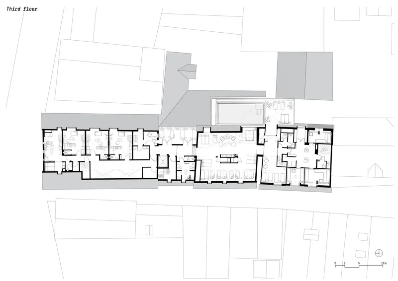 Third floor plan drawing showing residential units with central communal space and surrounding terrace areas