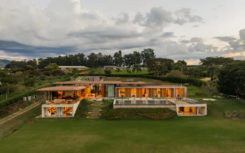 Aerial view of the stepped residence carved into the sloping lawn at twilight