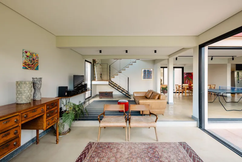 Open interior living space with stairs ascending to upper levels and sliding glass doors to terrace