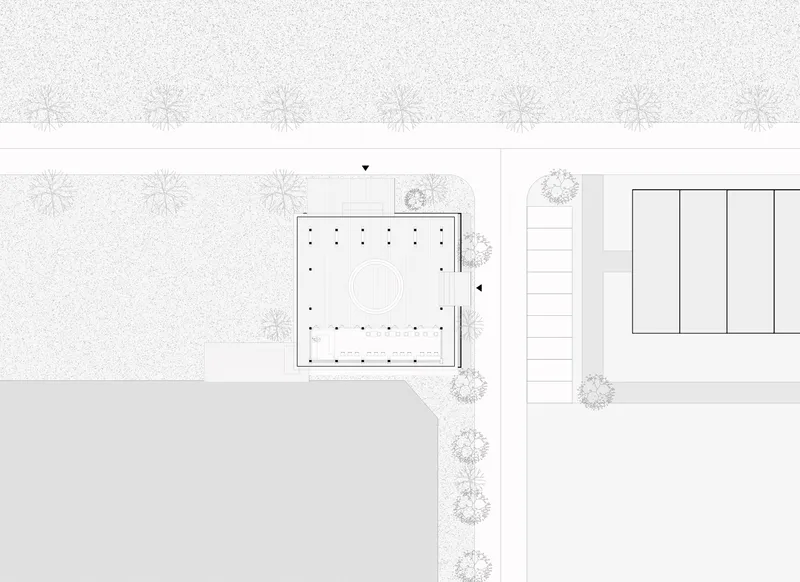 Site plan drawing showing a square building with central courtyard and tree-lined pathway to adjacent structure