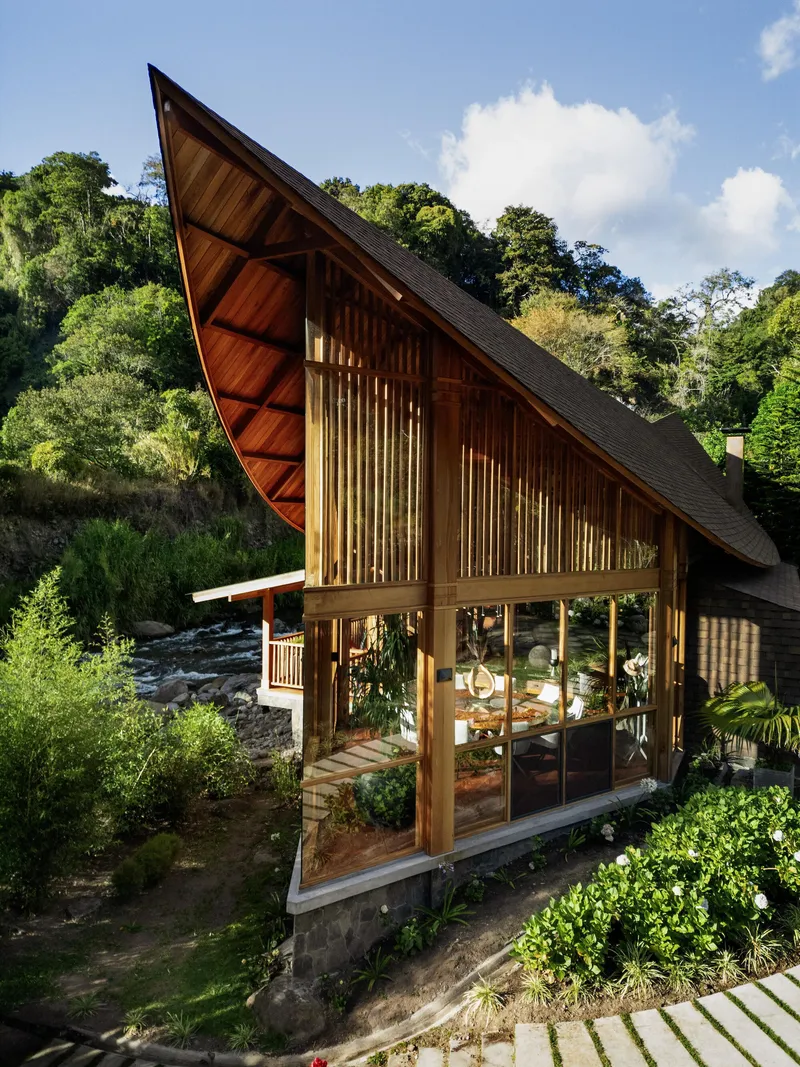 Elevated view of the glazed lower level with timber columns beneath the soaring gabled roof