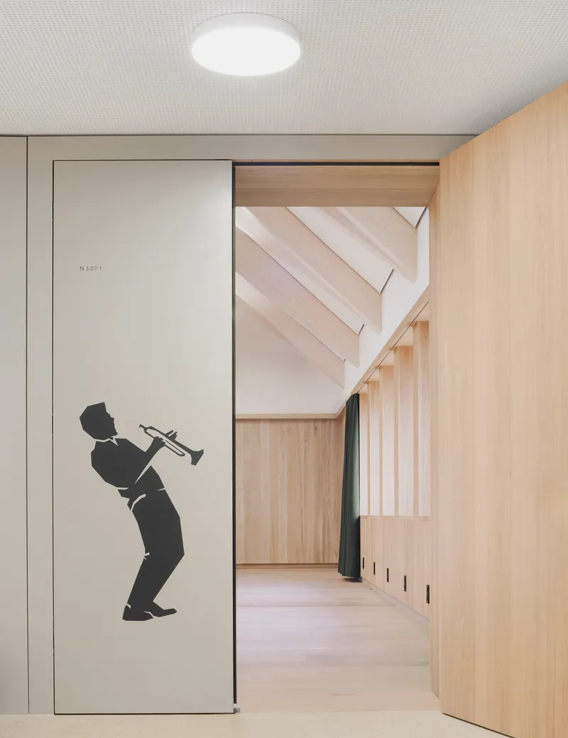 Corridor entrance with silhouette graphic of a trumpeter on a sliding door panel