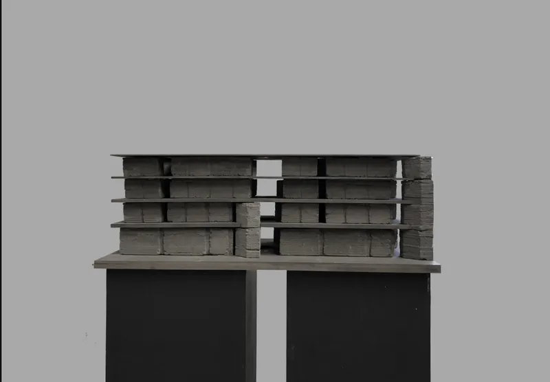 Layered physical model showing the rammed earth housing structure.