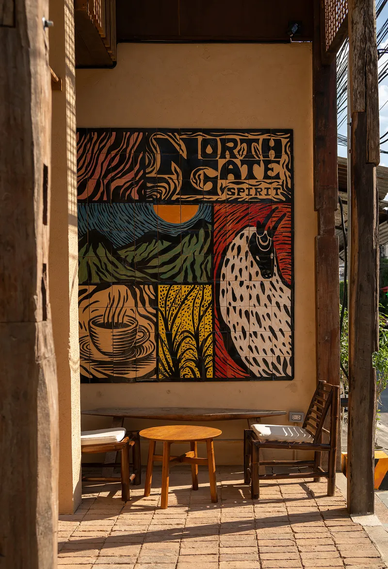 Interior courtyard seating area with mural and timber frame in morning sunlight