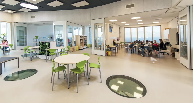 Flexible classrooms and shared learning areas support free movement, collaboration, and adaptable teaching methods.