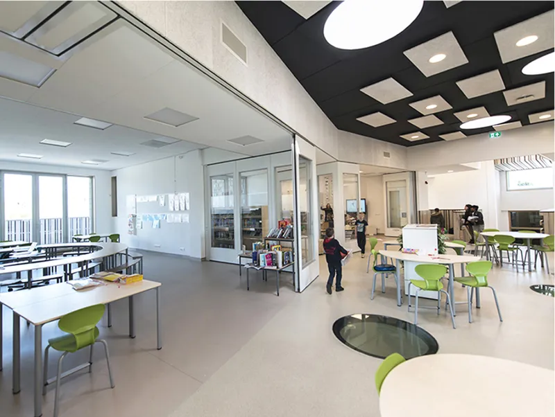 Open interiors, glass partitions, and playful ceiling details create a bright, modern space for digital and social learning.