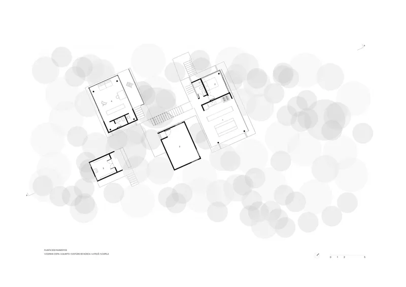 Floor plan drawing showing four rectangular volumes arranged around a central courtyard with surrounding trees