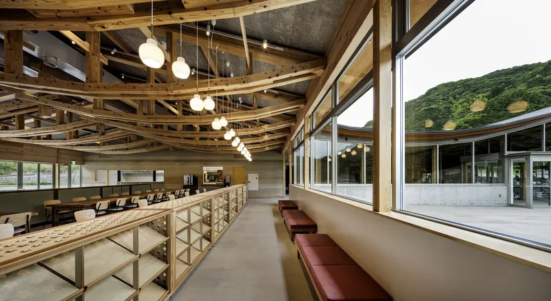 Corridor with curved timber ceiling beams and built-in seating along a window wall