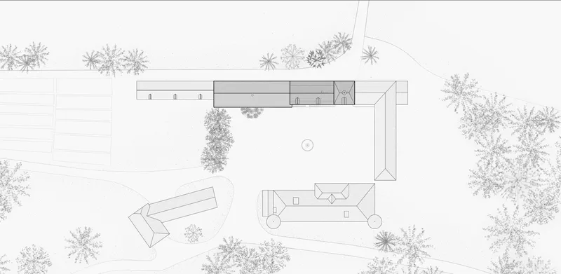 Site plan drawing showing two angled volumes arranged around a central courtyard with surrounding trees