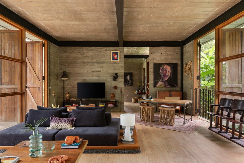 Living room with board-formed concrete wall and timber sliding doors flanking the main seating area