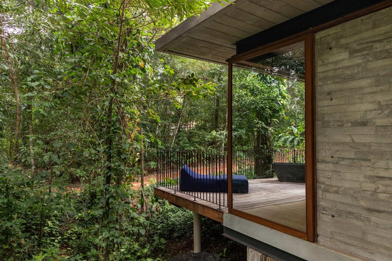 Elevated deck with timber-framed glazing and vertical steel railings extending into the landscape