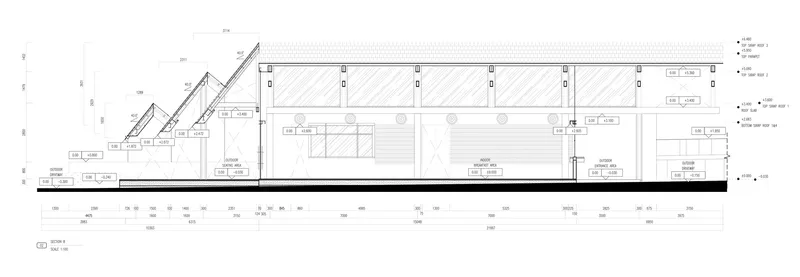 Section drawing showing a stepped auditorium with sloped seating rows and roof skylights above the main hall