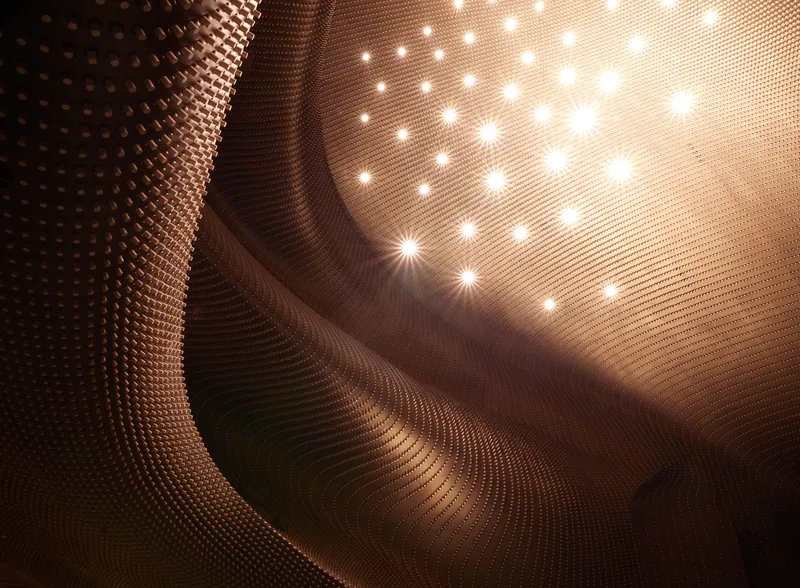 Close-up of the sculptural timber ceiling surface with embedded lighting creating starburst patterns