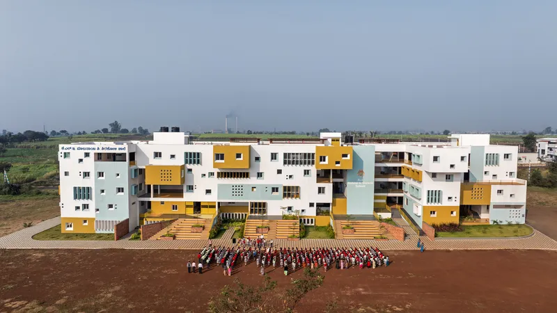 Aerial view of the entrance court with assembled students gathered on the brick paved plaza below the facade