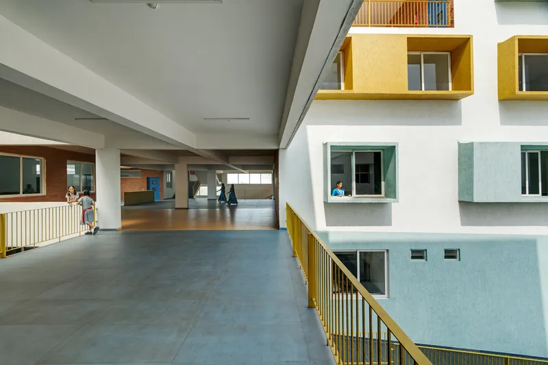 Circulation corridor overlooking the interior courtyard with yellow and blue painted window boxes