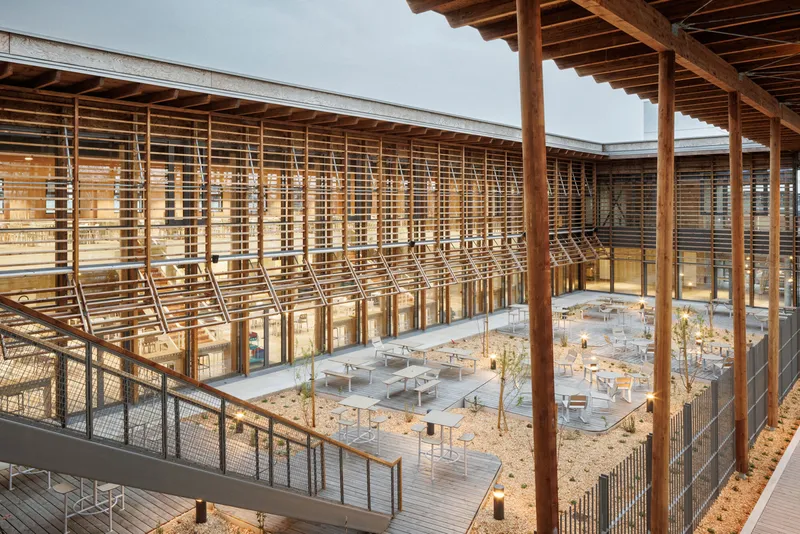 Elevated view of the central courtyard with timber lattice screens and exposed rafters framing scattered seating below