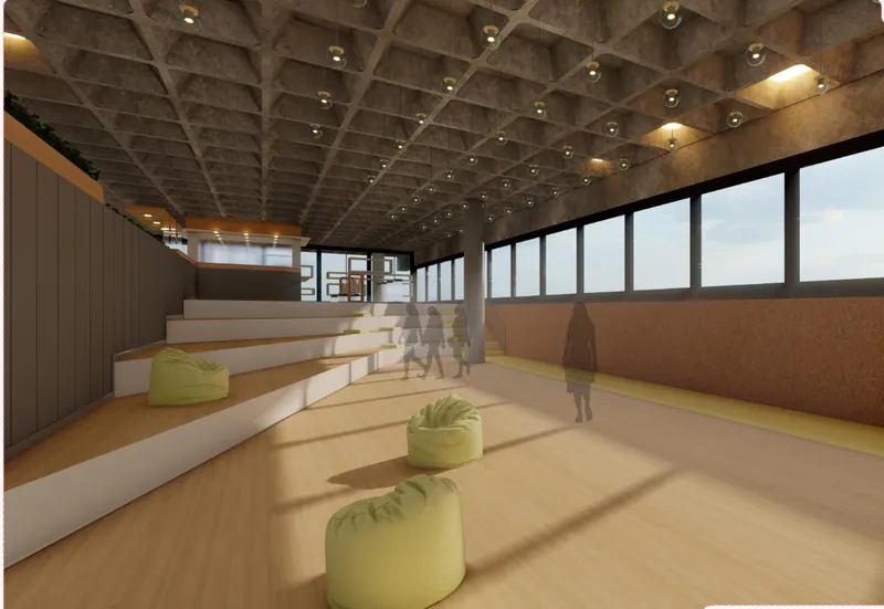 An open amphitheater-style learning zone with tiered seating, soft furniture, daylight, and a textured coffered ceiling.