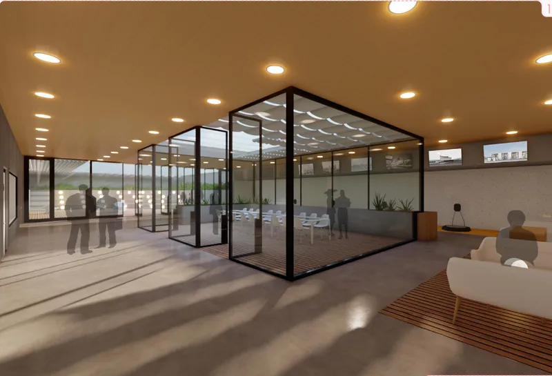 A transparent meeting and critique space framed by glass walls, lounge seating, and strong natural light.
